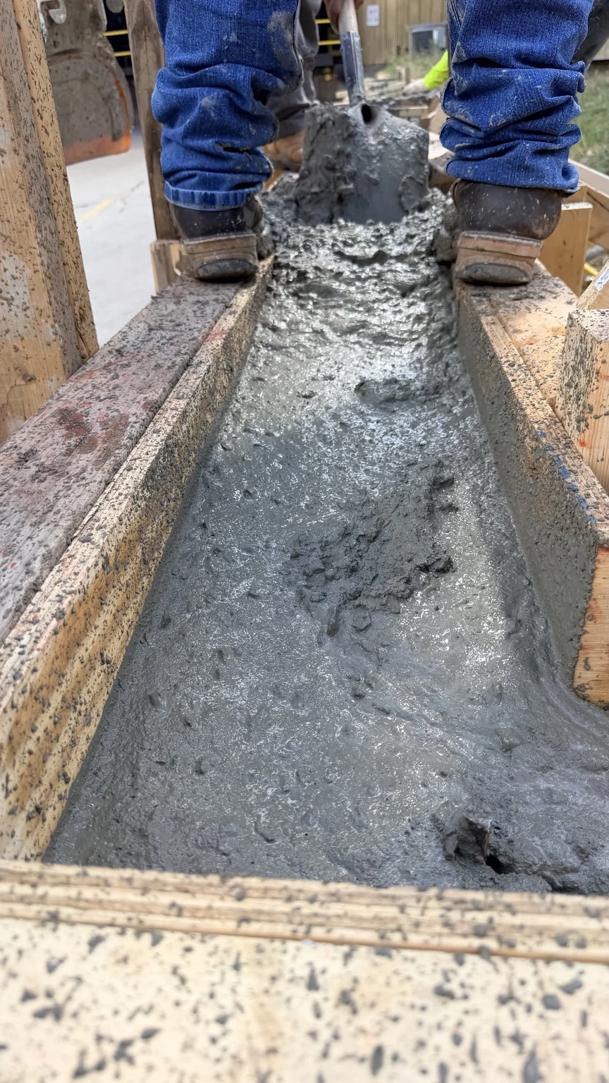 Fresh concrete being placed between wall forms