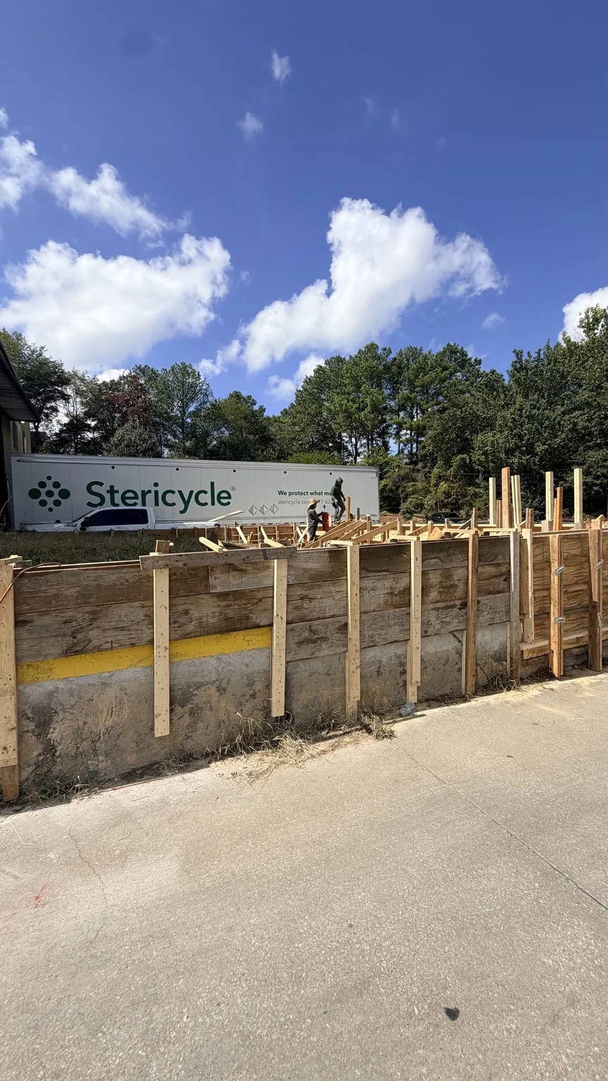 Timber wall formwork along the site with a Stericycle trailer in the background