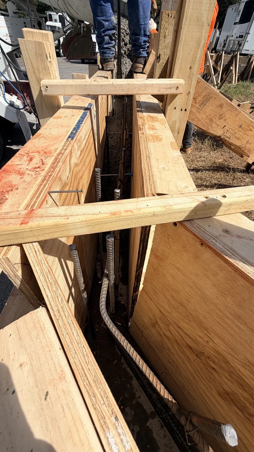 Concrete pour in progress within the formed wall